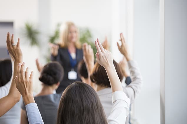 People raising their hands during a webinar