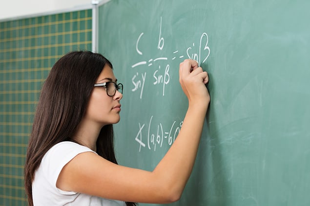 Student solving a math problem on a chalkboard