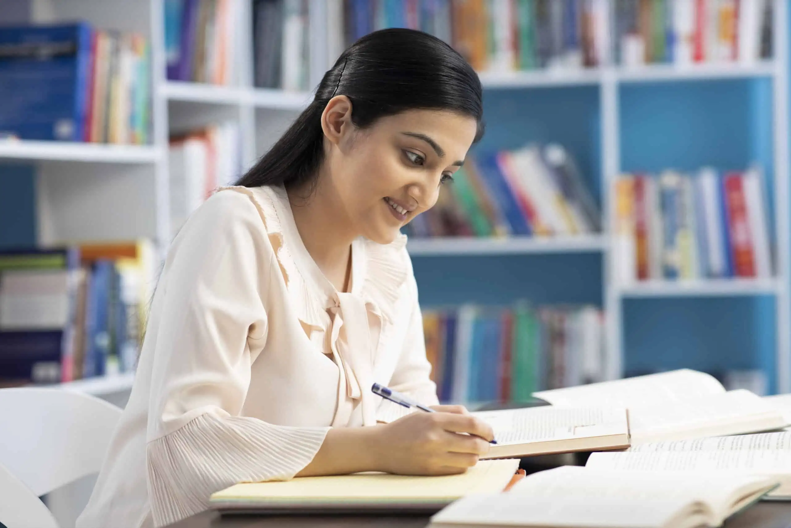 An Indian woman studies in a library.