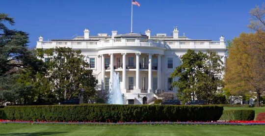 Featured image for blogpost of front view of the White House with an American flag