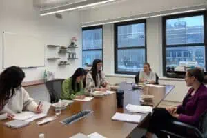 Group of adults working in a boardroom with workforce mentor.